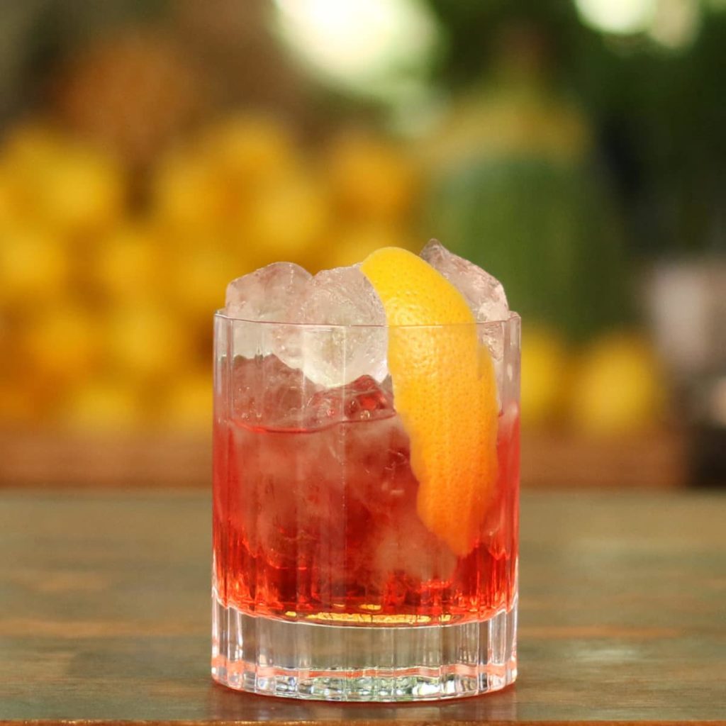 A Negroni cocktail resting on the top of a bar