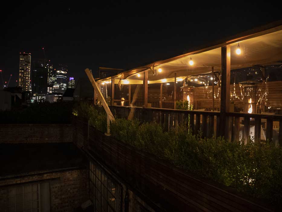 View of London skyline at night from roof terrace