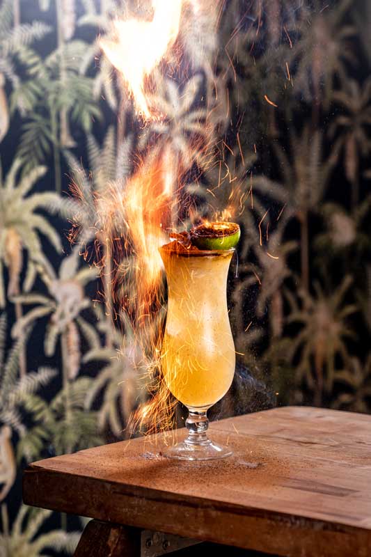 TT Mai Thai cocktail on a table top with flames and sparks coming off the top!