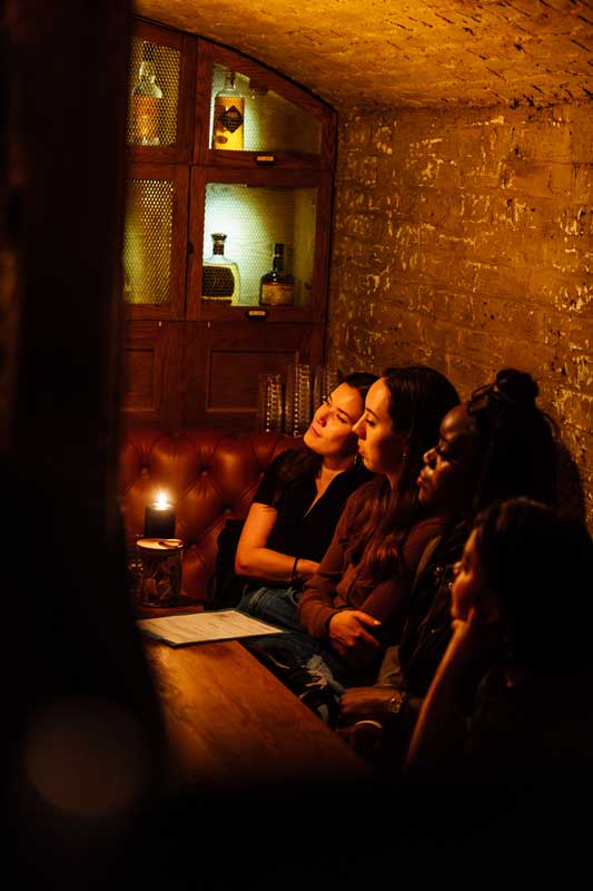 Three women sat in one of the Cellar Bar vaults enjoying an evening.
