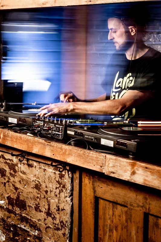 A DJ playing vinyl in the Cellar Bar.