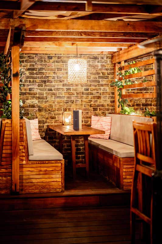 A seating booth on the Roof Terrace at night.