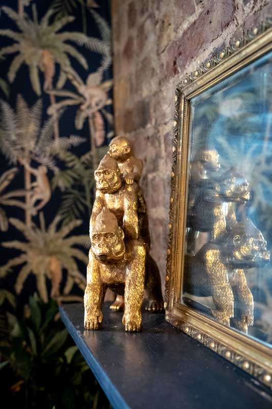 Gold statue of a family of gorillas on the mantlepiece in The Monkey Room.