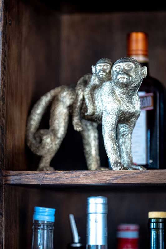 Silver statue of two of monkeys on a shelf in The Monkey Room.